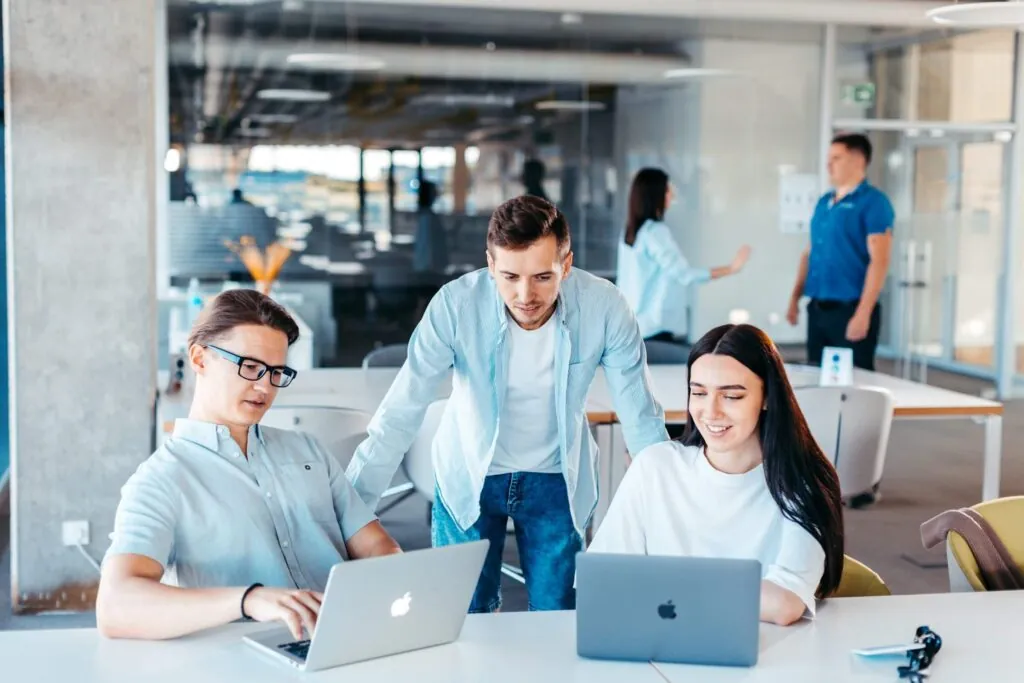 Team of professionals in an office with laptops.
